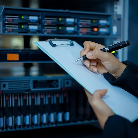 female technician or Network administrator working or checking data in a data center room. Selective focus; Shutterstock ID 1408363010; Purchase Order: purchase_order