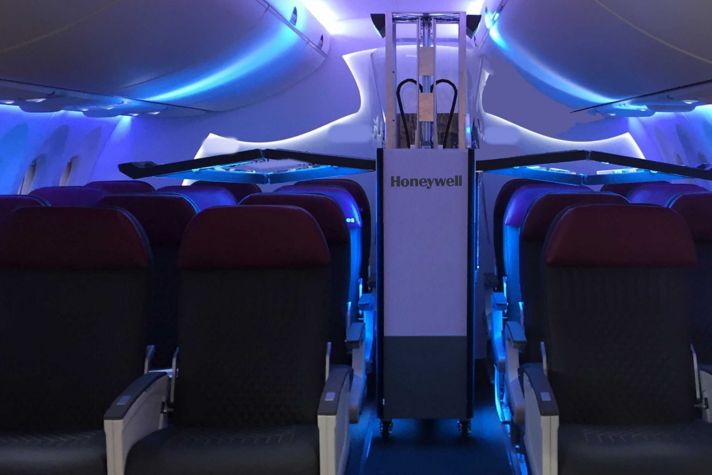 Honeywell UV Cabin System in airplane cabin aisle with arms extended over seating