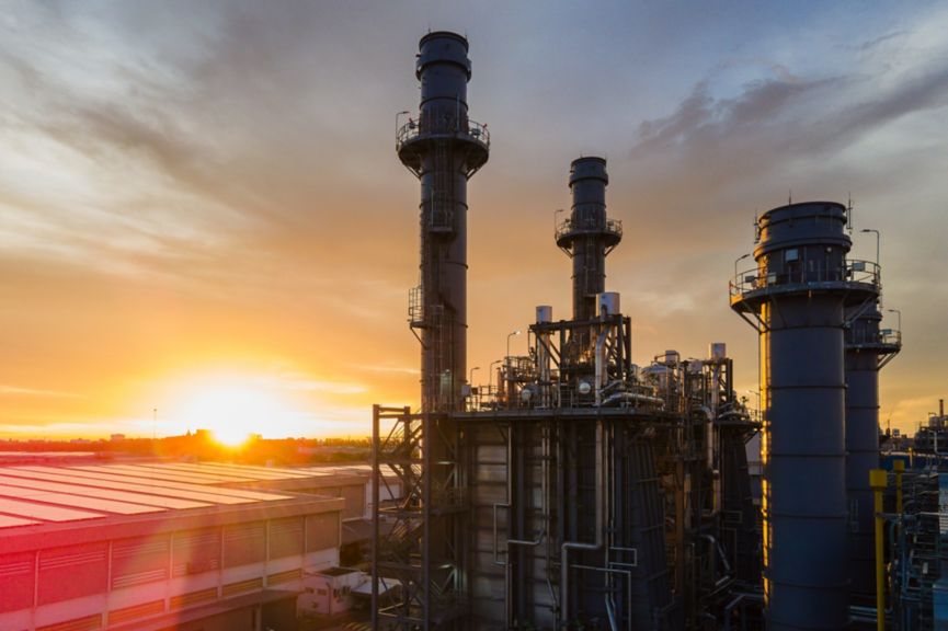 large industrial power plant set against a vibrant and colorful sunset sky, representing energy production, technology, and industrial advancement. The image captures the balance of industry and nature.